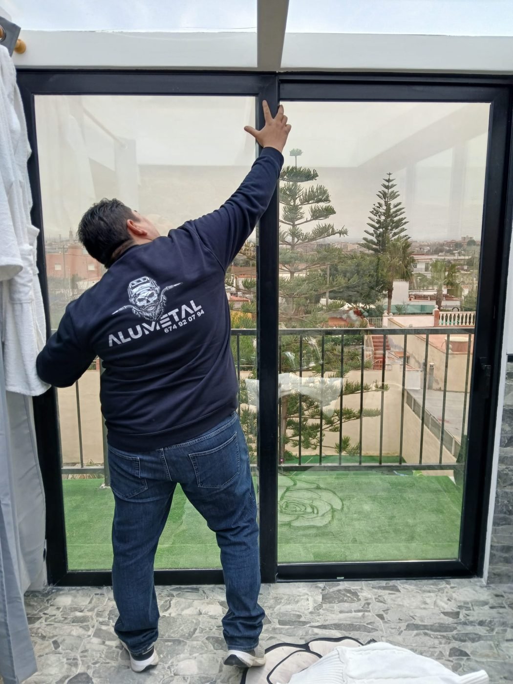 Operario de Alumetalrys instalando un ventanal de aluminio de marco negro