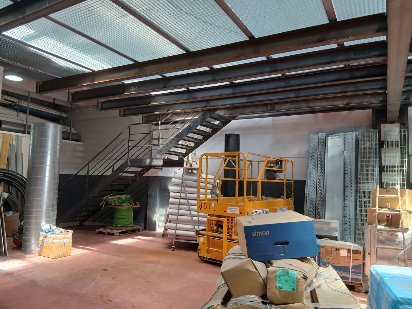 Interior del taller con maquinaria industrial y altillo metálico