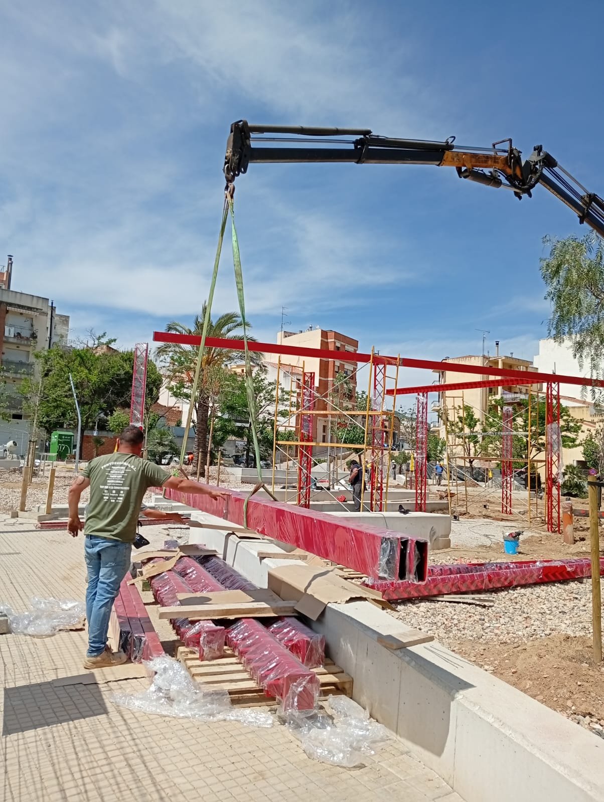 Operario guiando una viga de acero durante el montaje en obra