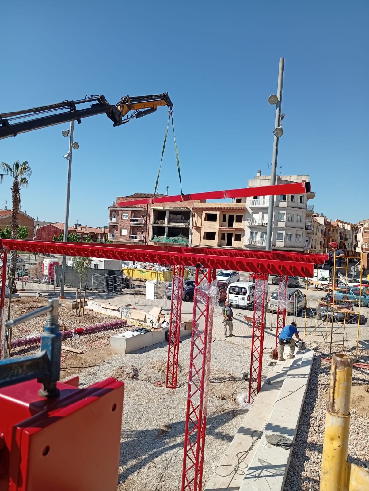 Grúa colocando una viga de acero en la estructura de una plaza